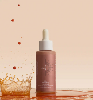 Hand applying drops to moisturizer